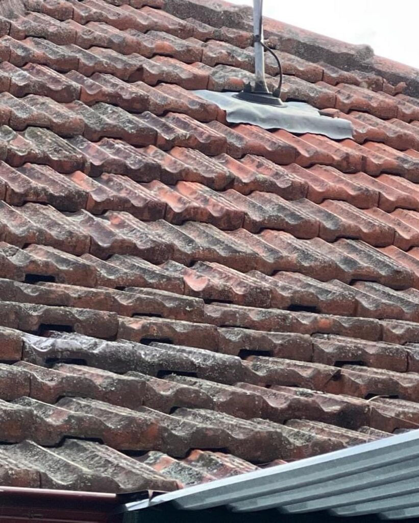 Professional roofer assessing storm-damaged residential roof