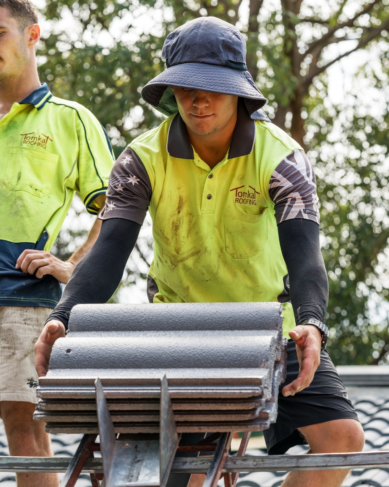 Roofing contractor repairing broken roof tiles and flashing during roof repair service.