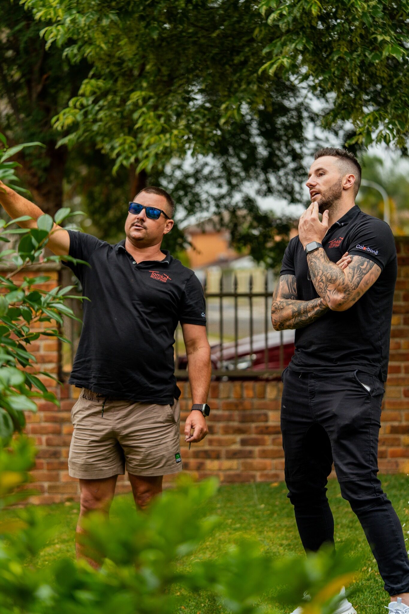 Tomkat Roofing team discussing roof repair Sydney project during on-site inspection.