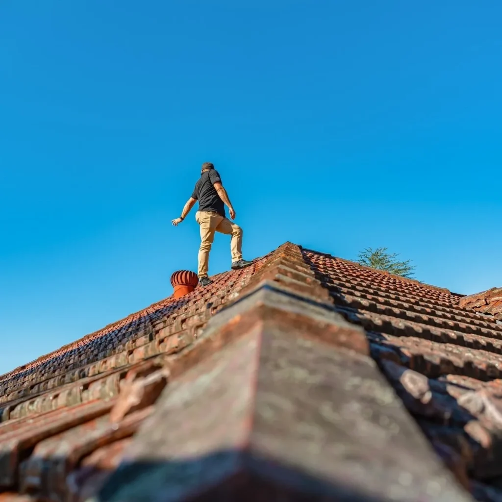 Roofing Contractor inspecting a tiled roof and preparing a detailed roof inspection report for homeowners.