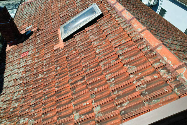 Damaged terracotta roof tiles needing repair after a storm in Sydney.
