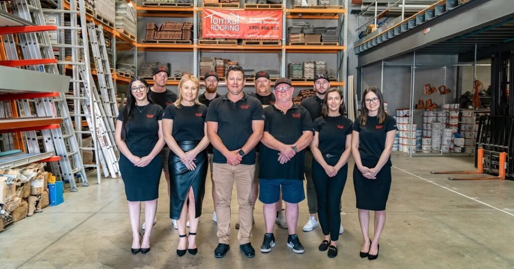 Tomkat Roofing team in a warehouse, ready to provide expert roof restoration services in Sydney.