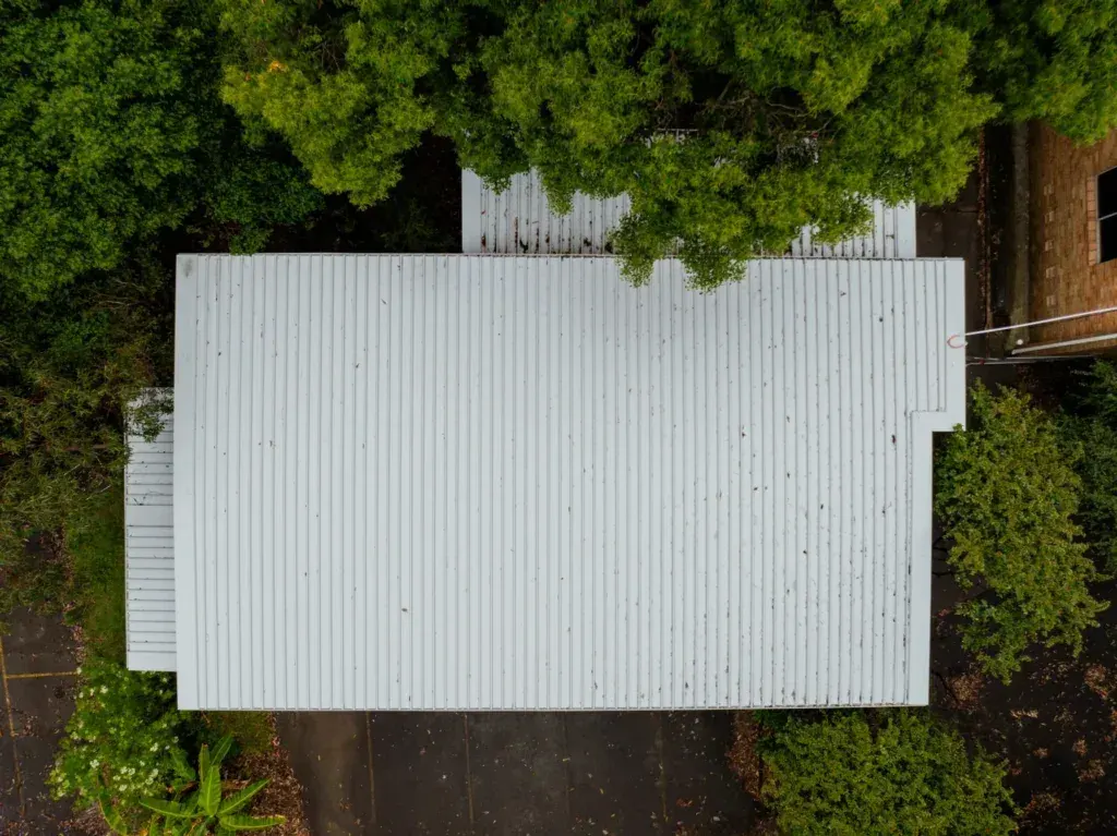 Completed metal roof replacement on Sydney brick home with burgundy corrugated roofing