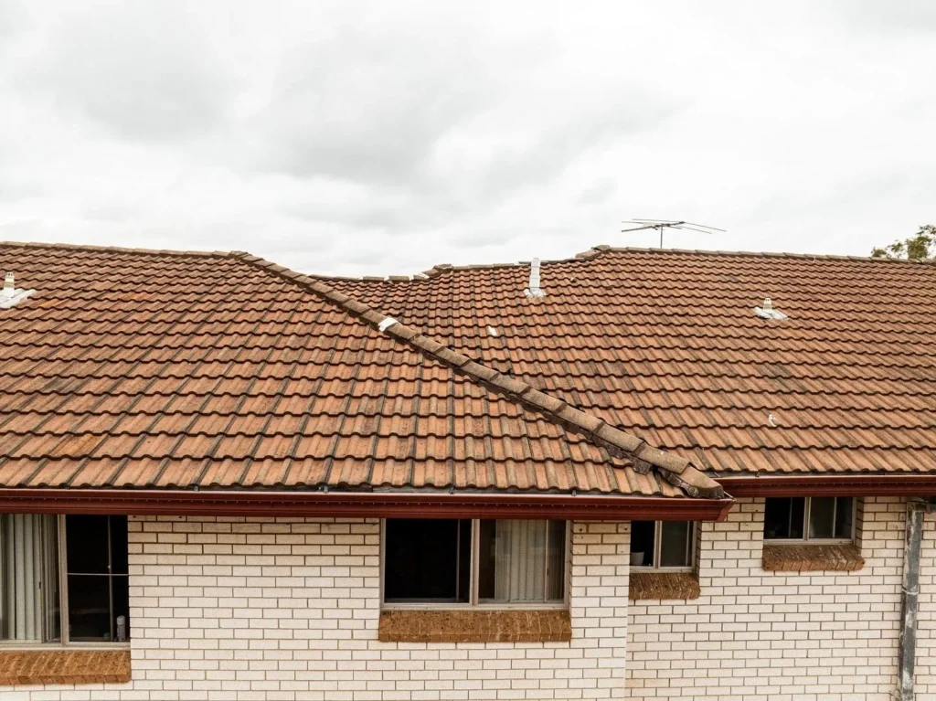 Roof rebedding work in progress showing scaffolding and gutter installation on Sydney home.