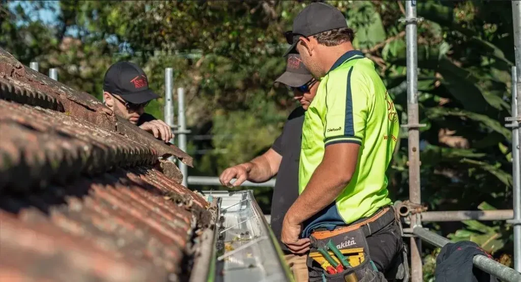 Tomkat Roofing licensed contractors inspecting roof leak repair for quality workmanship.