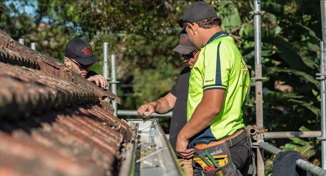 Tomkat Roofing licensed contractors inspecting roof leak repair for quality workmanship.