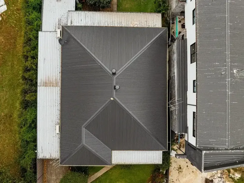 Aerial view of Colorbond metal roof installation in dark grey showing hip roof design Sydney