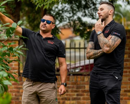 Tomkat Roofing team discussing roof repair Sydney project during on-site inspection.