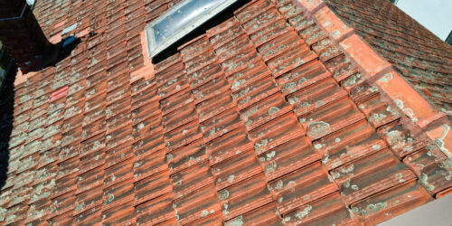 Damaged terracotta roof tiles needing repair after a storm in Sydney.